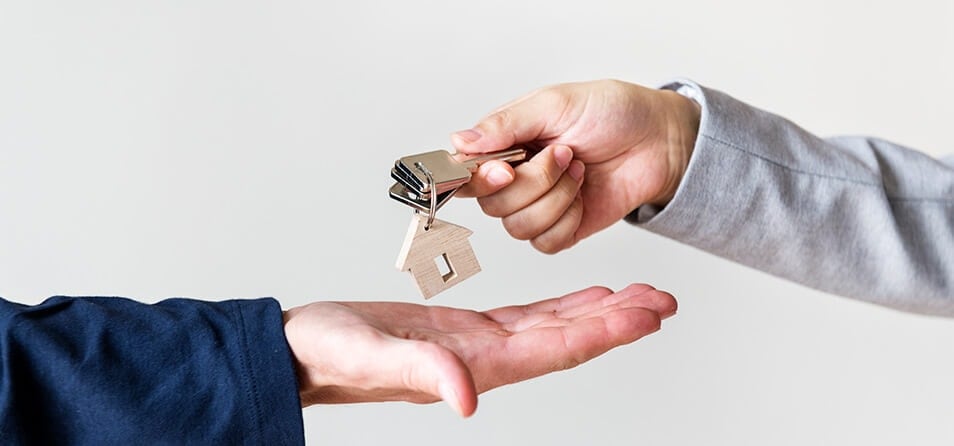 Imagem de uma pessoa entregando chaves para a outra