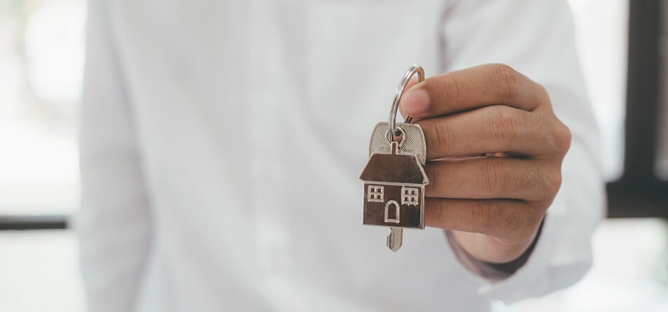 Imagem de uma pessoa mostrando as chaves de uma casa