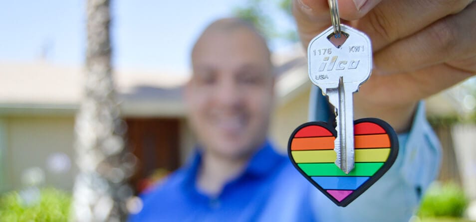 Pessoa segurando a chave de uma casa em um chaveiro de coração