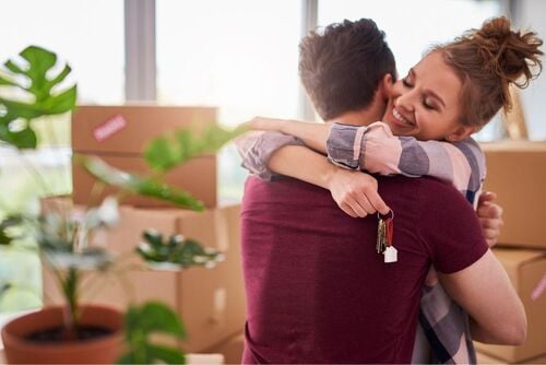 homem e mulher se abraçando com uma chave na mão