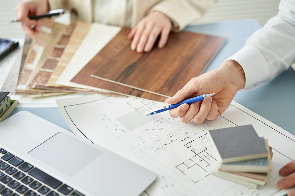 Planta baixa de imóvel e arquitetos avaliando benfeitoria