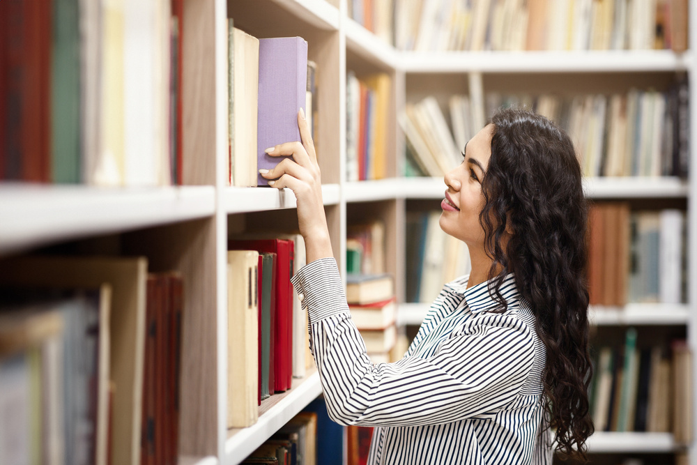 Mulher em biblioteca de uma das melhores faculdades de Brasília