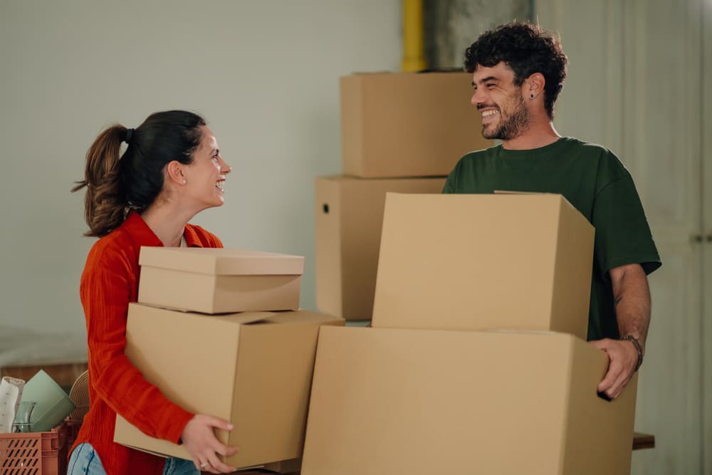 Casal sorridente realizando mudança. Quero me mudar. 